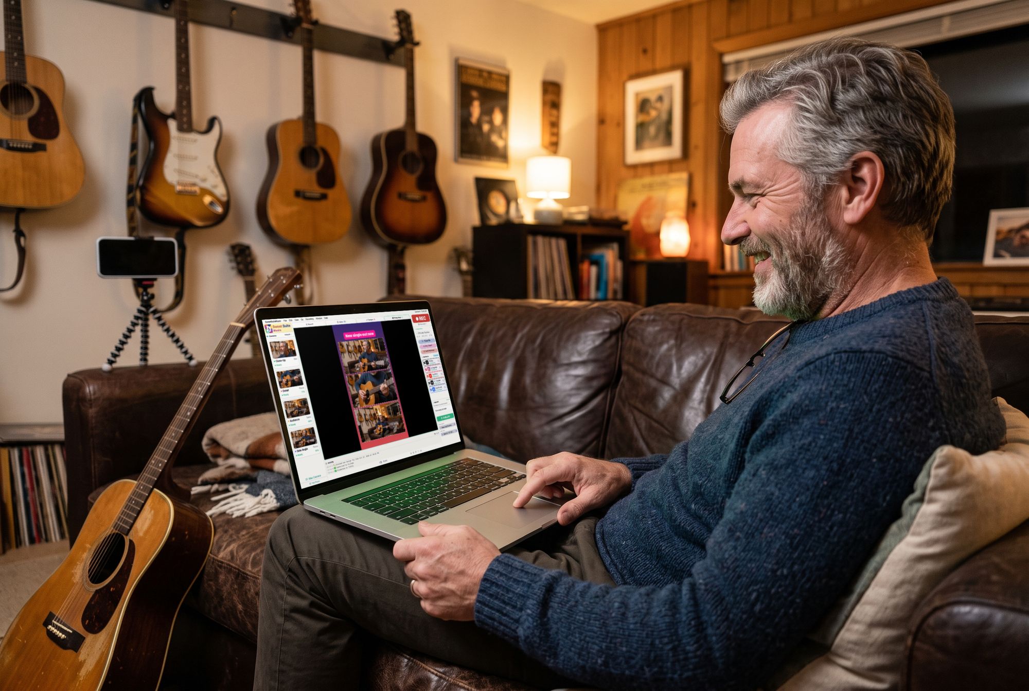 A guitarist on his couch grins at his laptop, about to publish his finished video